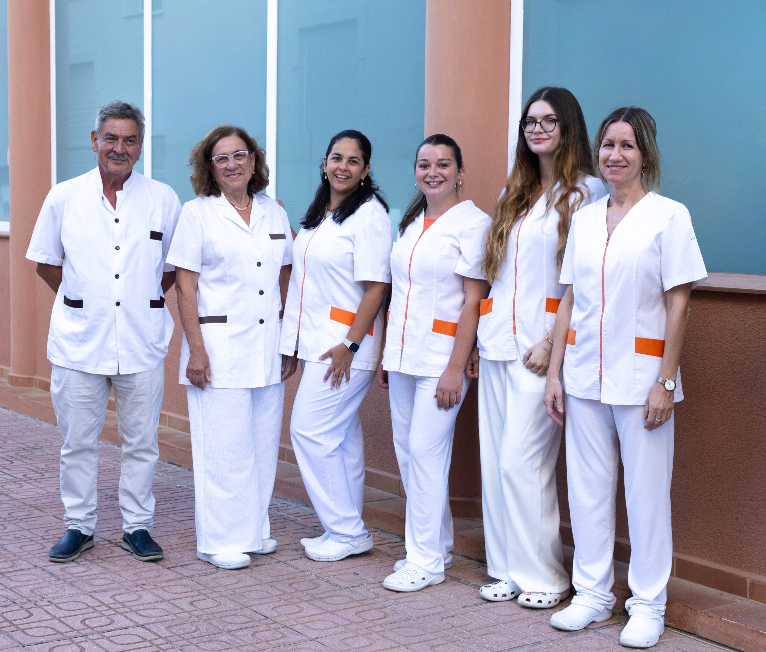 Equipo médico y personal sanitario de Policlínica CUME en Jávea, posando en el exterior del centro de salud con uniformes blancos.